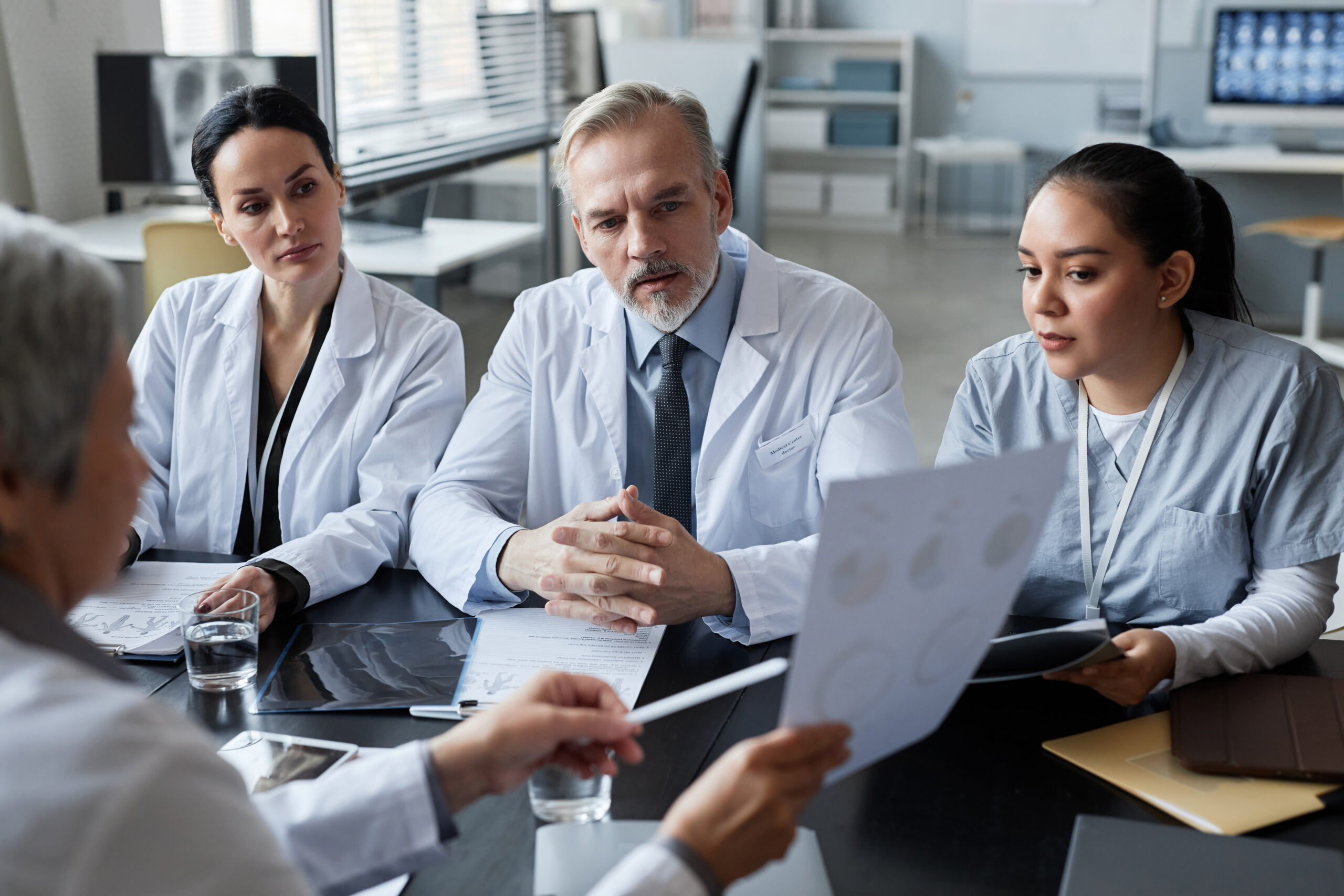 Focus on group of young and mature clinicians looking at data on document